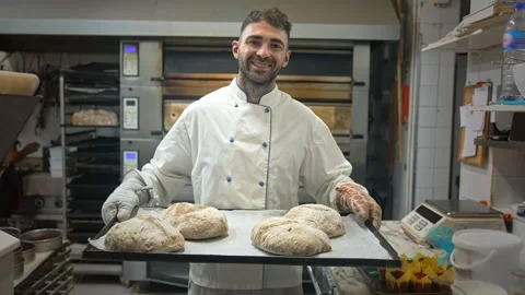 Happy baker cooking bread bakery. Smiling person bake tasty loafs. Man portrait. 動画素材 273278574
