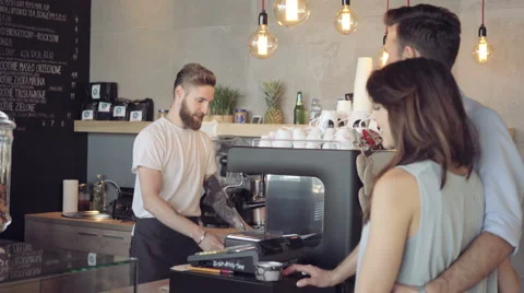 Happy barista serving coffee ordered by young couple Stock Footage 64650994