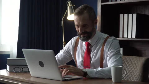 Happy  bearded business man using laptop computer take off  glasses and bit i 動画素材 158757196