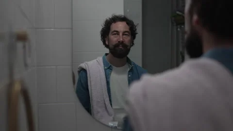 Happy bearded man brushing teeth in mirror Stock-Footage 336624691