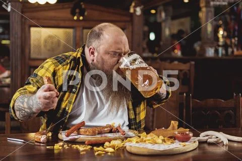 Happy bearded man drinking glass of beer Stock Photos