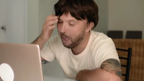 Happy bearded man in a wig is playfully preening on a video call Vídeo Stock 145746360