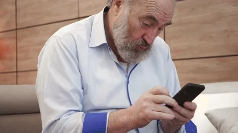 Happy bearded senior elderly 70s man user holding smart phone watching mobile vi Video stock 148948959