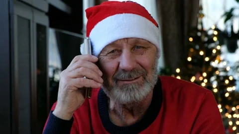 Happy beared senior man in red christmas hat talking on the smart phone Stock Footage 144873935
