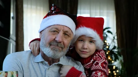 Happy beared senior man in red christmas hat with his grandson, celebrating new Stock Footage 144969574