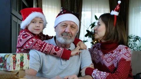 Happy beared senior man in red christmas hat with his grandson and adult daughte Stock Footage 145048366