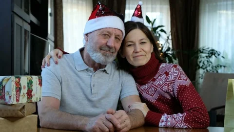 Happy beared senior man in red christmas hat with adult daughter, celebrating ne Stock Footage 145191374
