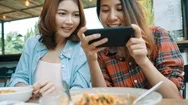 Happy Beautiful Asian Friends Women Blogger Using Smartphone Photo At Cafe. Stock Footage