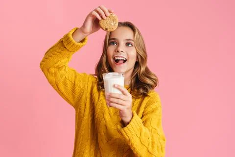 Happy beautiful blonde girl eating cookie with milk Stock Photos