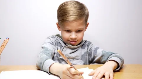 Happy beautiful boy drawing and writing in notebook. child concentrates Video stock 123201848