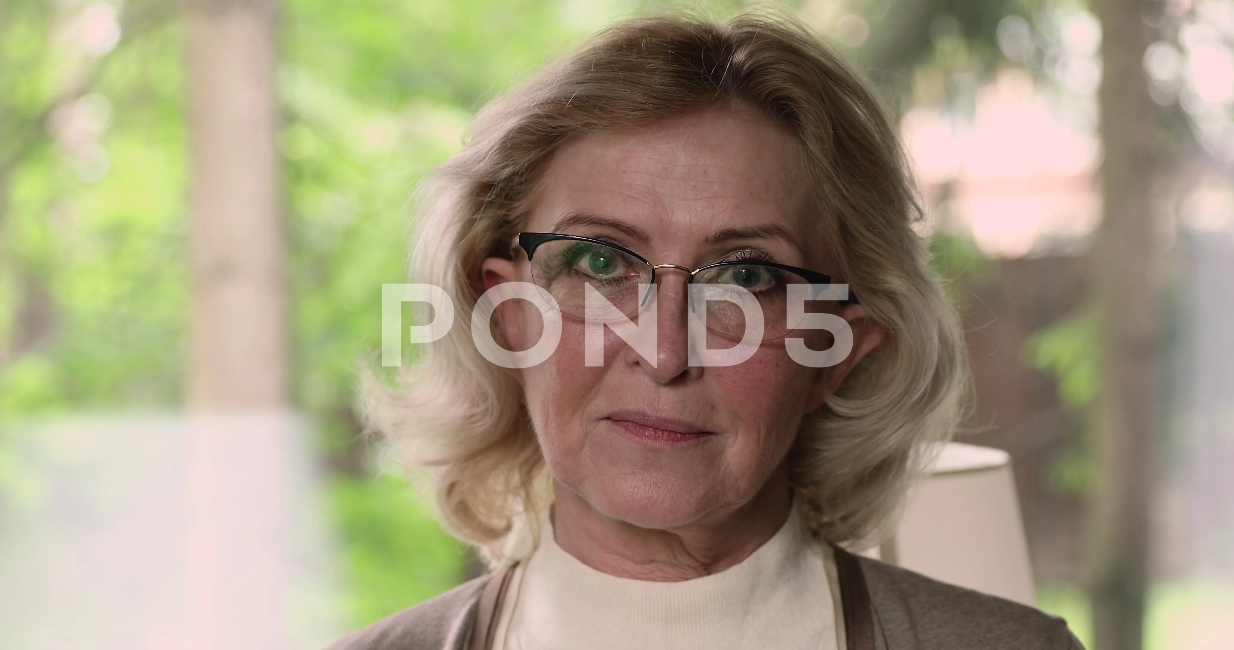 Happy beautiful older senior woman in eyeglasses looking at camera.