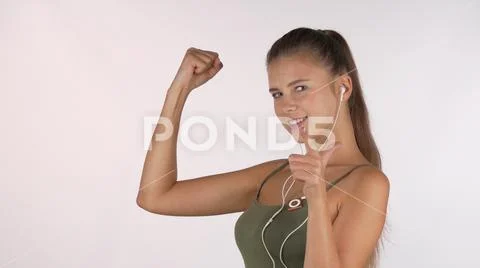 Happy beautiful sportswoman showing her biceps, pointing to the camera at you Stock Photos