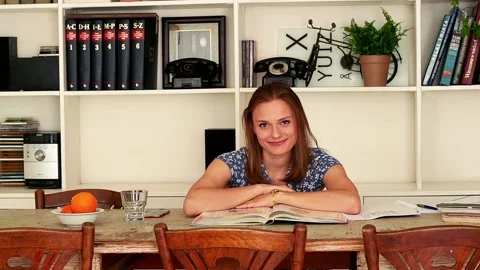 Happy, beautiful student smiling when learning by table at home Video stock 91625670