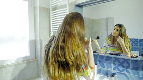 Happy beautiful woman dancing while putting makeup in front of mirror Stock Footage 65396682