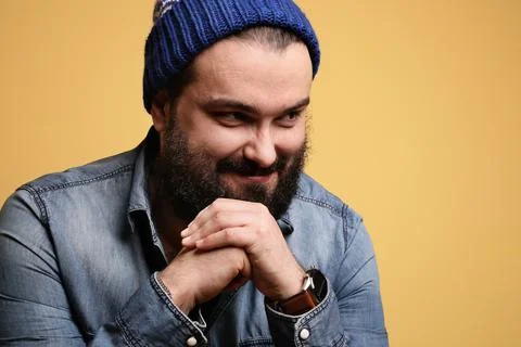Happy big man with beard, posing over yellow background looking aside. Isolated. Stock-Fotos