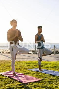 Midsection of biracial man practicing yoga meditation sitting in