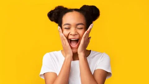 Happy black girl screaming and holding cheeks Stock Photos