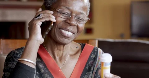 Happy black woman completing her prescription drug order on her cell phone Stock Footage