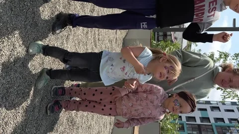 Happy blond child having fun and dancing on the playground in the courtyard of Stock Footage 244280709
