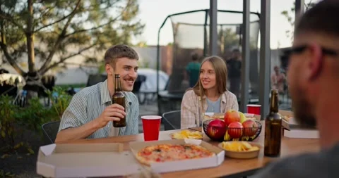 A happy blond guy with a bottle of beer in his hands communicates with his Vídeos de archivo 281362988
