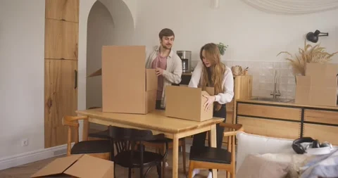 A happy blond guy with stubble and his blonde girlfriend collect things and put Video stock 309468960