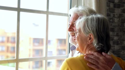 Happy bonding loving middle aged senior retired couple standing near window.. Stock-Footage 231622326