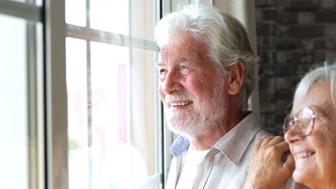 Happy bonding loving middle aged senior retired couple standing near window.. Stock-Footage 231623405