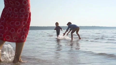 Happy borthers playing on the beach splashing water slow motion. Laughing kids  Stock Footage 132999806