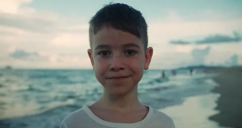 Happy boy 8 to 9 years old smiling close up at the beach. Childhood emotions Stock Footage 313961286