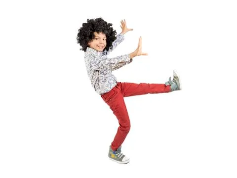 Happy boy in afro wig dancing. Isolated. White background. Stock Photos
