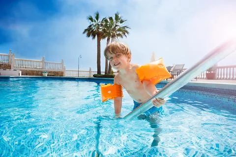 Happy boy arm floaties about to dive in the pool Stock Photos