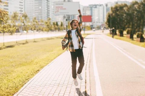 A happy boy with a backpack and a tablet returns home from school. The studen Stock Photos