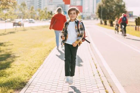 A happy boy with a backpack and tablets returns home from school. The student Stock Photos