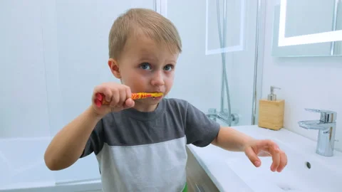 Happy boy is brushing his teeth. Child with a smile shows his chewed teeth to Stock Footage 131161029