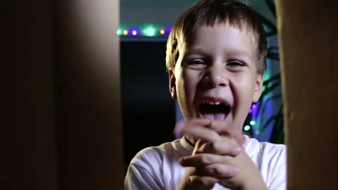 Happy boy child opens the box and enjoys the gift for the holiday. Close-up Video stock 141893427