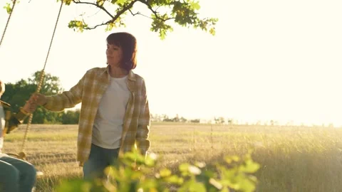 Happy boy enjoys flight feeling on handmade swing spending time with mom Stock Footage 257346830