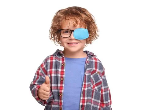 Happy boy with eye patch on glasses showing thumb up against white backgrou.. Fotos de archivo