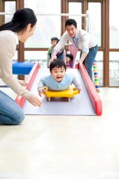 Happy boy going down a slide in kindergarten Foto stock