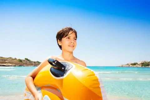 Happy boy with inflatable float on tropical beach Stock Photos