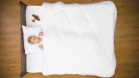 The happy boy lay on the bed with toy plane. Real time capture. View from above Stock Footage 71965788
