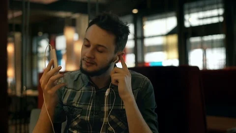 Happy boy listening music in the dark cafe and singing Stock Footage