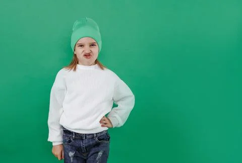 A happy boy is making faces and having fun on the background of a green studi Stock Photos