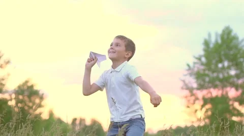 Happy boy with paper airplane on the field over sunset background Stock Footage 59081383