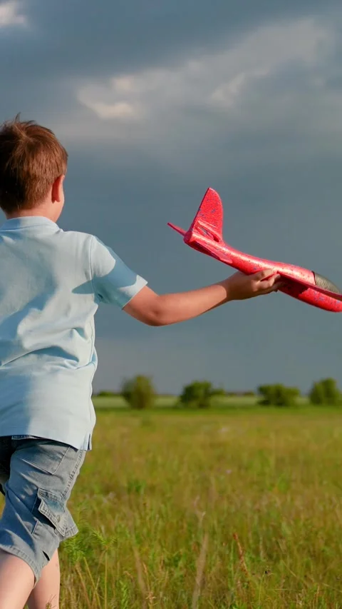 Happy boy play run on summer meadow against sky with toy airplane, slow motion Stock Footage 295789355