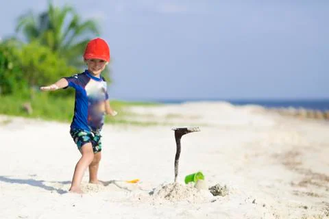 Happy boy playing on the beach Stock Photos