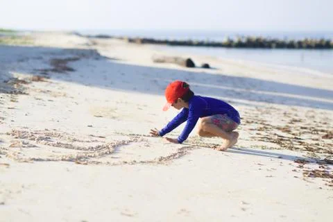 Happy boy playing on the beach Stock Photos