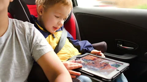 Happy boy playing game on pad during car travel Stock Footage 42735071
