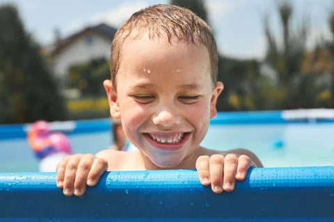 Happy boy playing in a pool Stock Photos