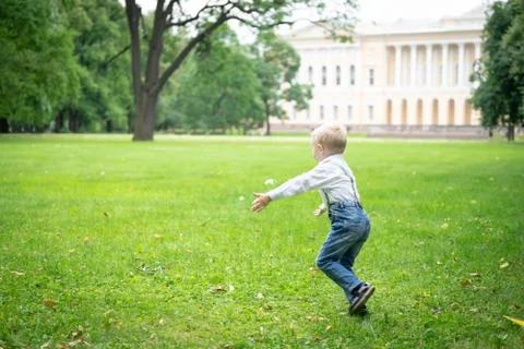 Happy boy playing with soap bubbles in the park in the grass. Stock-Fotos
