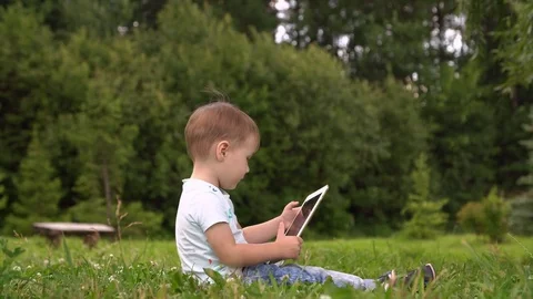 Happy boy playing in tablet outdoors. Slow motion Stock Footage 78729960